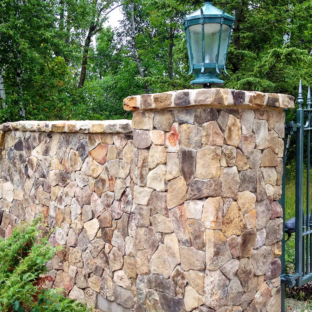 Picture of building stone veneer on a retaining wall and gate column