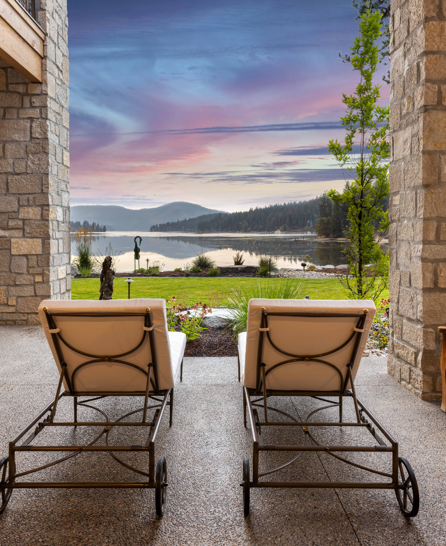 Out door furniture positioned to overlook Hayden Lake through a stone-framed view